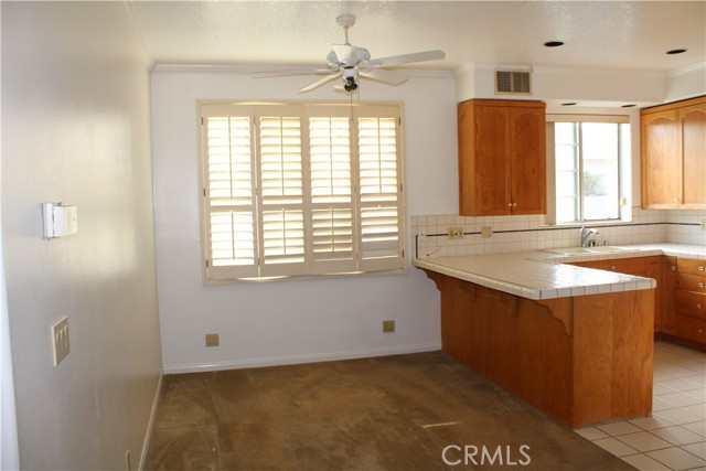 Dining area off kitchen. Natural light through large windows. Original wood shutters.