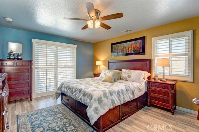 Large master suite with stunning flooring, attached balcony, plantation shutters, ceiling fan, and resort level en-suite master bathroom!