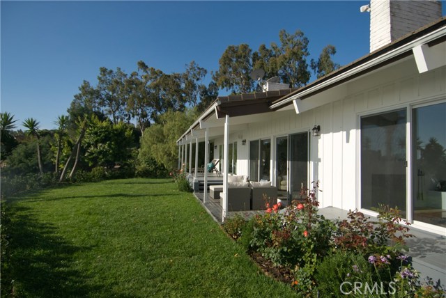 Landscaped yard has a large number of mature fruit trees.