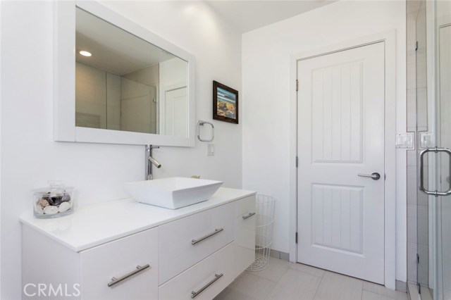 With tasteful touches found throughout, this full bath for the bedrooms spaces offers clean white cabinetry and a spacious shower.