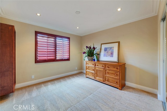 Upstairs bedroom with built-in shelving and mirrored wardrobe doors