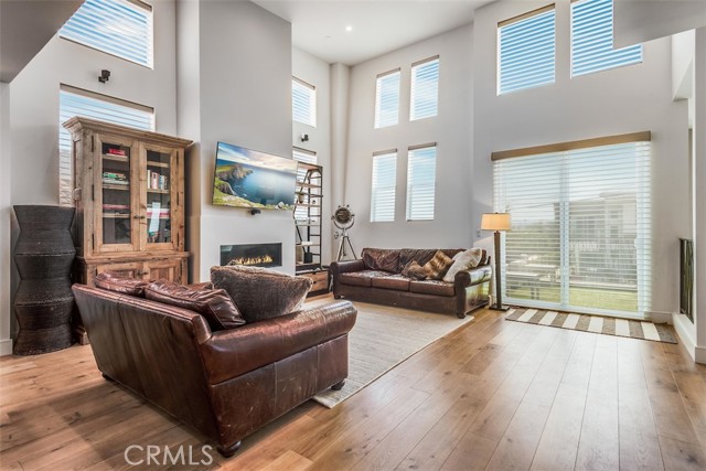 Living room with oak flooring soaring ceilings and incredible fireplace.... voice controlled shades in 