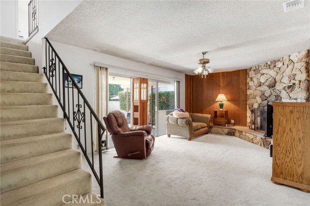Family room and stone fireplace opens to covered patio and yard. Stairs to 3 bedrooms upstairs.