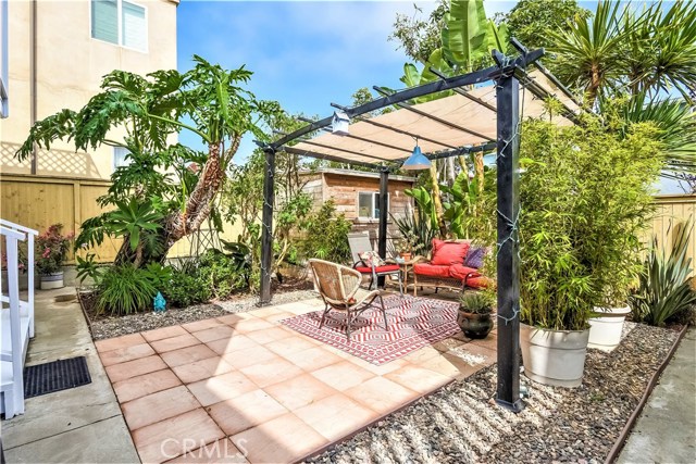 The rear yard has tropical mature trees, paver decking, a lanai seating area and a storage room.