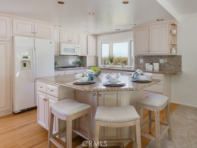 Open concept kitchen with island, granite countertops, custom cabinets.