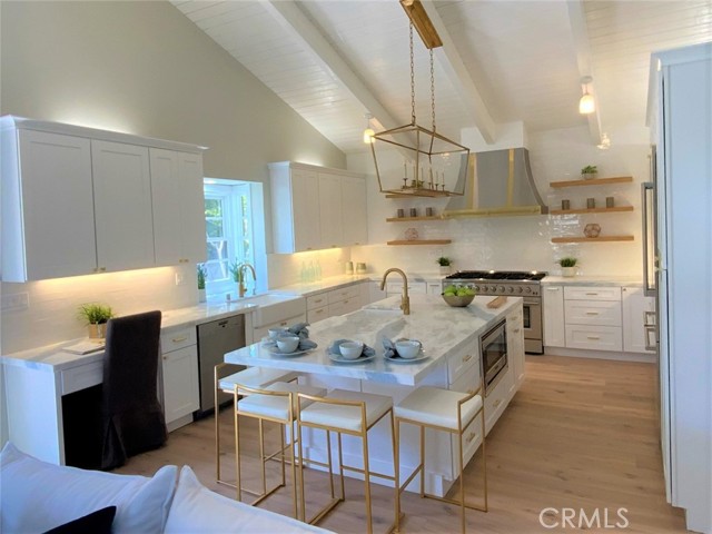 the warm blue striations in the granite slab countertops bring the beach into this modern elegant kitchen. Notice the second prep sink on the island and convenient microwave location. seating for 4 at the island for fast meals or just sipping your morning coffee