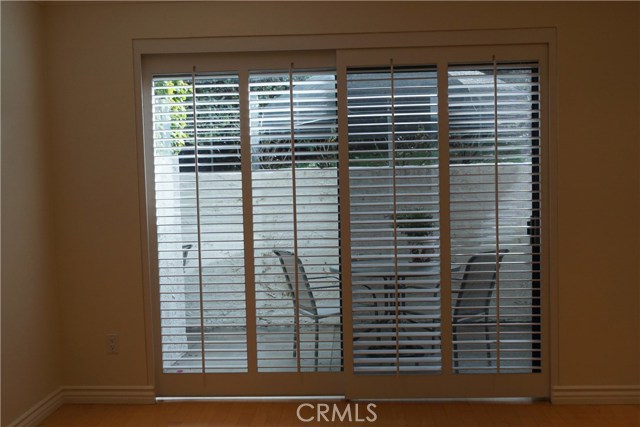 Sliding glass doors and sliding plantation shutters doors to front patio for morning coffee.