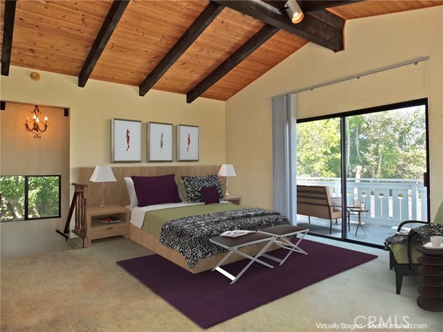 Upstairs master suite featuring vaulted ceilings, views, & private balcony.