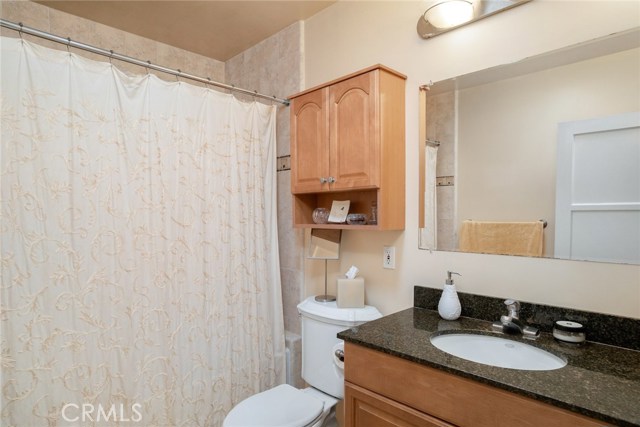 Large hallway bathroom has tiled shower and floors.