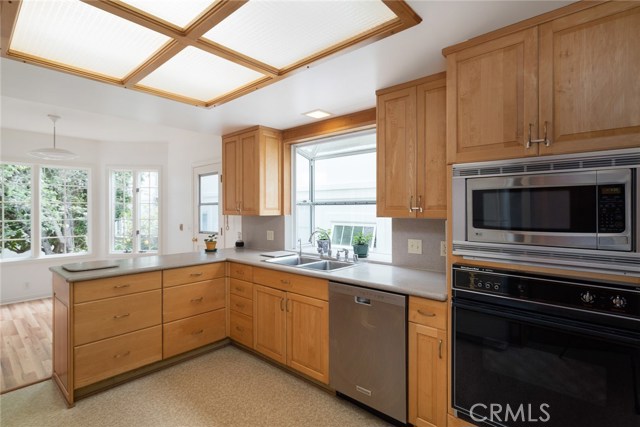 Sunny kitchen has nook, Corian counters, maple cabinetry, greenhouse window, blt-in appliances and large walk-in pantry.