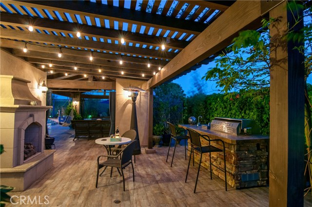 Freestanding fireplace, built in grill, sink and refrigerator complete the outdoor kitchen.