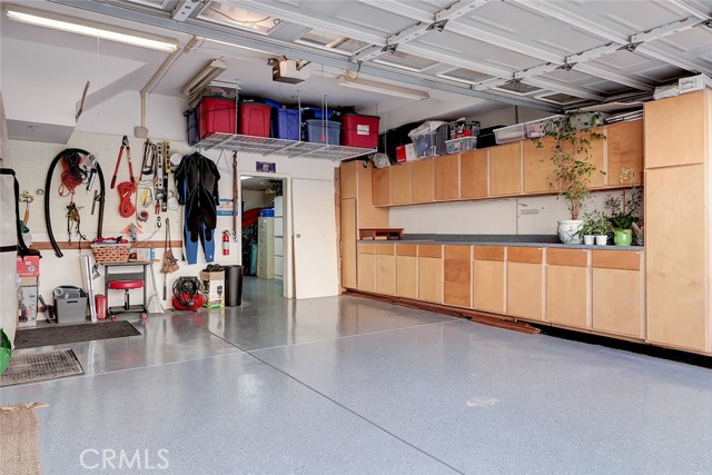 Attached 2 car garage with direct interior access, ample built-in storage cabinets, and an epoxy floor.