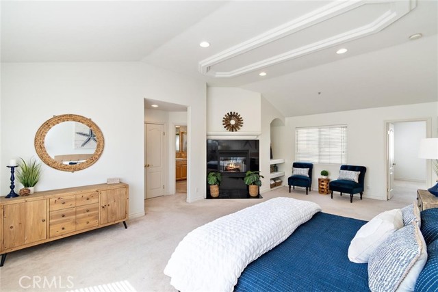 View towards linen closet, bathroom, fireplace, sitting area, and adjoining bedroom.