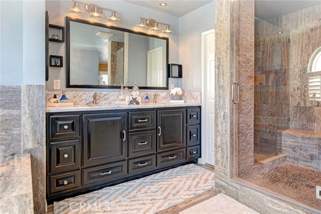 Masterfully updated resort level en-suite master bath with marble, jetted tub, dual sinks, designer vanity, and an absolutely stunning stone walk-in shower.