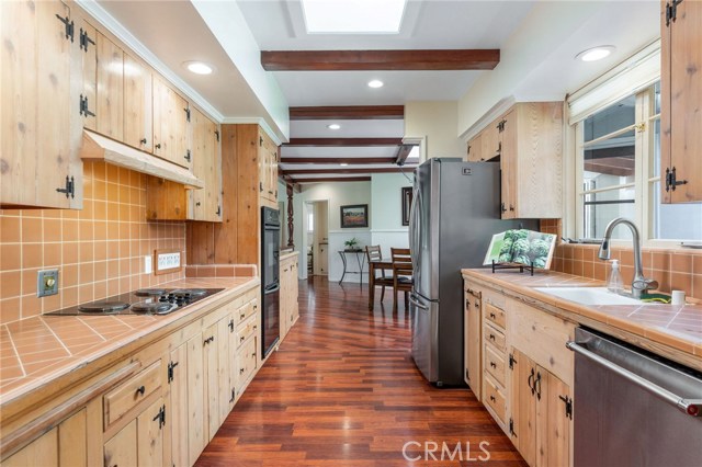 The spacious galley style kitchen has solid wood cabinetry and classic tile work - embrace the timeless style or customize to you own design.