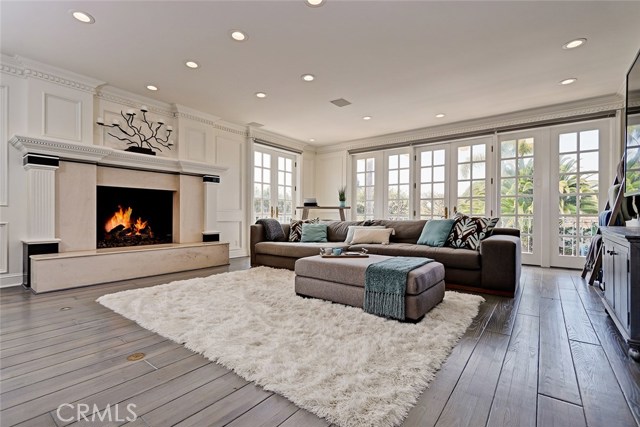 Spacious and clean-lined, the Family Living space is anchored by a roaring, gracious fireplace, and displays contemporary, light gray hardwood floors, which play off the special wall moldings.