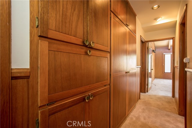 The hallway between the 2nd and 3rd bedrooms is lined with wooden storage cabinets. The large full bath is on the right between the two bedrooms.