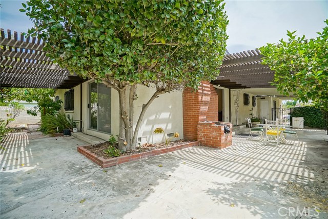 There is access to the back patio spaces from the living room and the dining room. This shows the corner of the home with both patios in view.  Also, notice the wood burning grill and chimney just outside the dining room slider.