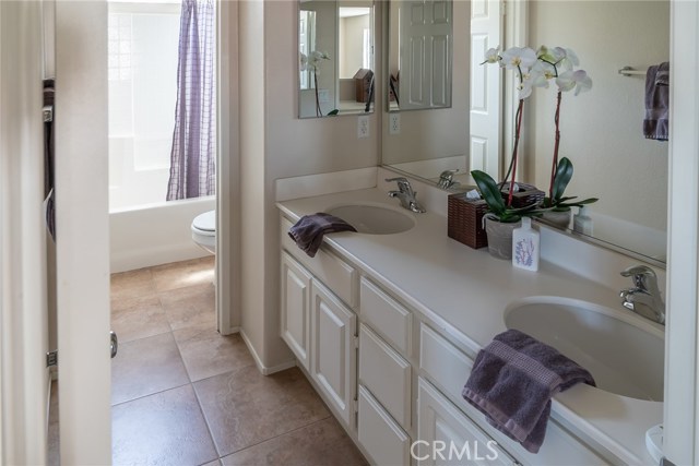 Upstairs bathroom with double sink and separate bath/tub and toilet room