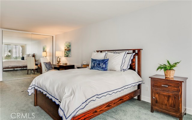 Plantation shutters ward off afternoon sun, floor to ceiling mirrors and large closets add to bedroom.