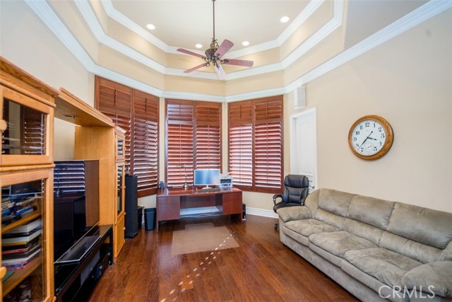 Large Office with Plantation Shutters, Wood Floor, Ceiling Fan and Coffered Ceiling.