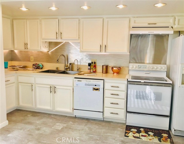 bright kitchen with upgraded Quartz countertop, sink, faucet, backsplash, range hood, new disposer