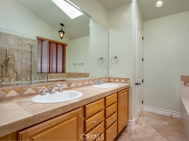 Master bath has gorgeous stone flooring and counters with maple cabinetry.