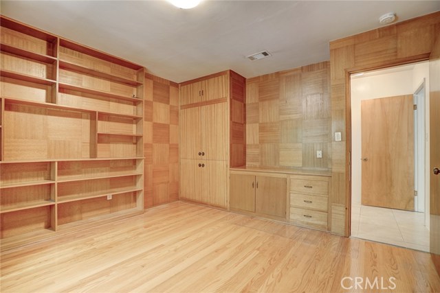 A full wall of bookcases as well as a wet bar cabinet and desk space.