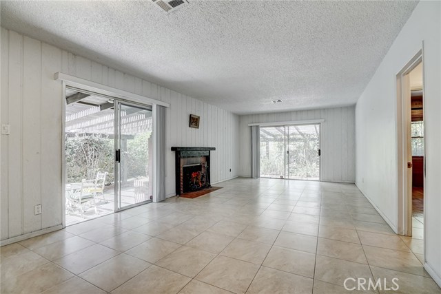 The spacious living and dining area has ceramic tile flooring and two sliding doors that go out to the serene back gardens.