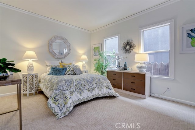 Spacious guest bedroom with custom crown molding and baseboards.
