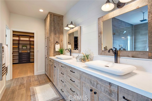 Master bathroom with reclaimed wood vanity, dual sink, Calico Quartz countertops, towel warmers and entry to absolutely huge walk-in closet.