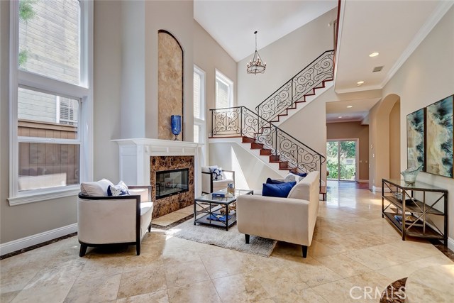 Stunning entry and living room with soaring ceilings and striking fireplace with floor to ceiling stone.