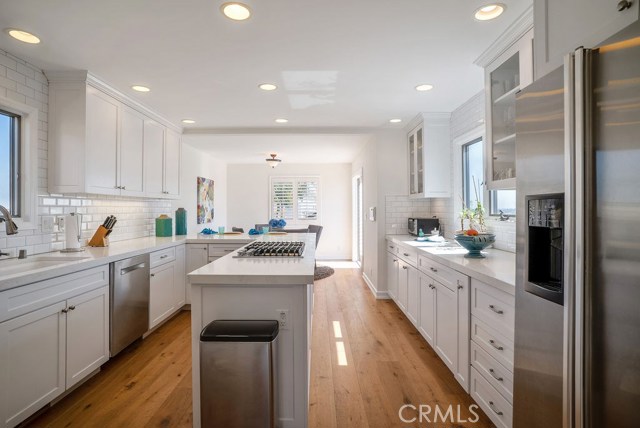 Exquisitely designed custom kitchen with stainless appliance, Bosch dishwasher, 6-burner cooktop, Calacatta Ravenna Sequel Quartz counter tops, breakfast bar, eating area, and double doors leading to the view deck.