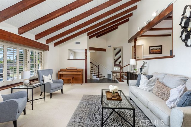 The ocean view living room brings gorgeous golden sunsets in a picturesque setting. With a large warm fireplace, exposed rich wood beam ceiling, and the open style space adds to the highlights of the home.