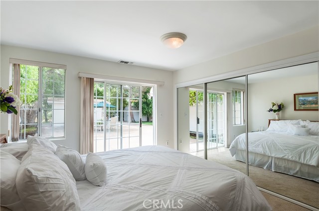 Sunny and bright Master Suite has sliding door to backyard, 8' mirrored wardrobe and its own full bathroom.