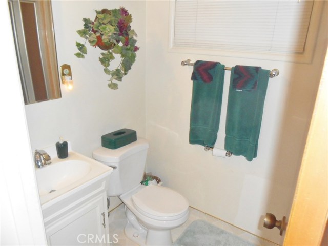 Bathroom Adjacent to Utility room with Stand-Up Shower, Vanity and Toilet.