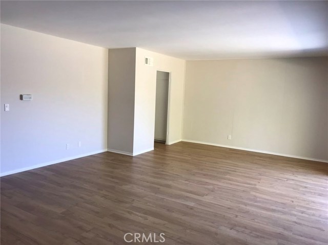 Living room with dining area, looking back at entry to kitchen