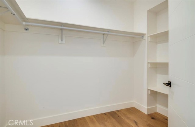 The spacious master bedroom closet has custom shelving and hanging racks