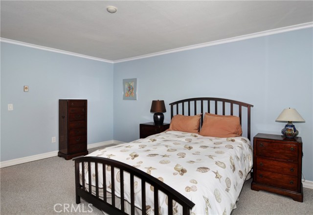 Large Master bedroom with recessed lights and crown molding