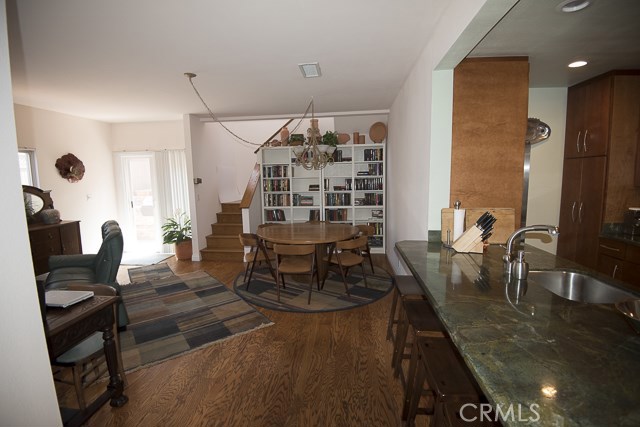 View of dining area and kitchen counter and 4 stool seating area.