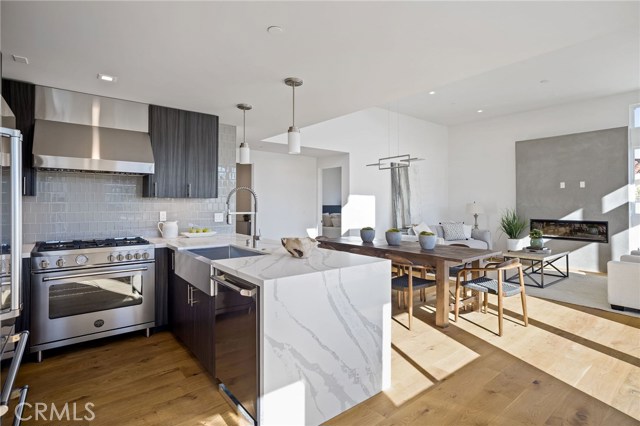 High-end kitchen with stainless appliances, quartz countertop with waterfall side