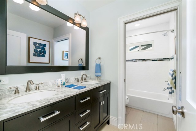 This full bathroom services two of the bedrooms upstairs (the other two are en suite), smartly with the pocket door between vanity and shower room.