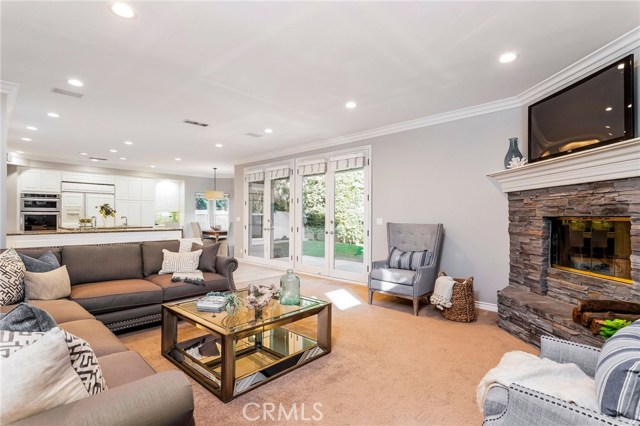 Family room with double French doors leading to spacious, grassy backyard