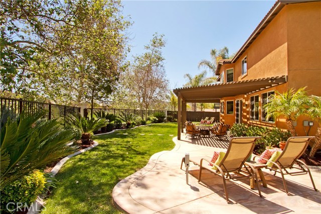 Large lattice covered patio extends the width of the house with custom hardscape and landscaping