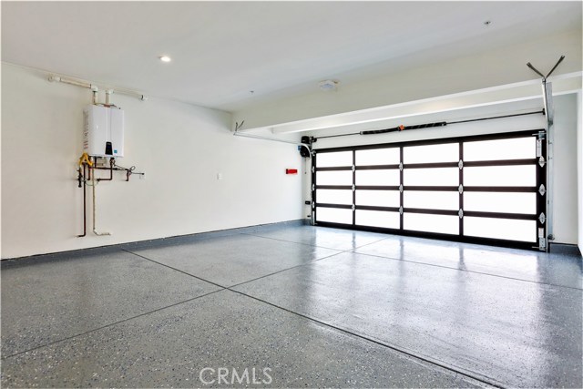 The Large 2-Car Garage has a Custom Stacked Glass Panel Door, Upgraded Liftmaster Side Motor Wi-Fi Opener, Motion Sensor Lighting, Epoxy Coated Flooring, A Navien High Capacity Tankless Water Heater with an Instant Hot Circulating Pump, Wide 2-car Driveway Apron and Adjacent Street Parking