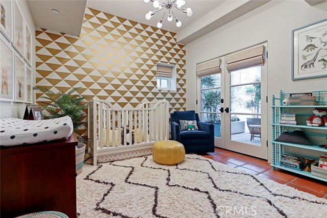 Third guest bedroom at lower floor level with french doors to adjacent patio.