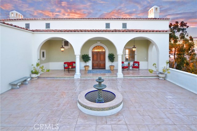 Charming Front Courtyard with its lovely fountain and delightful covered porch is ready to welcome guests.