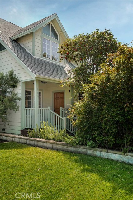 View of front door and covered porch from next door neighbors yard. Large dormer window upstairs is one of 3 bedrooms and 2 baths upstairs inc Master suite