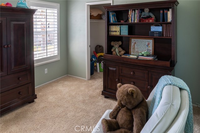 Upstairs bedroom with walk-in closet and view of front yard