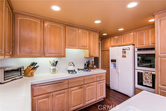Clean white tiles, warm wood cabinetry and endless storage make the kitchen lovely and functional!